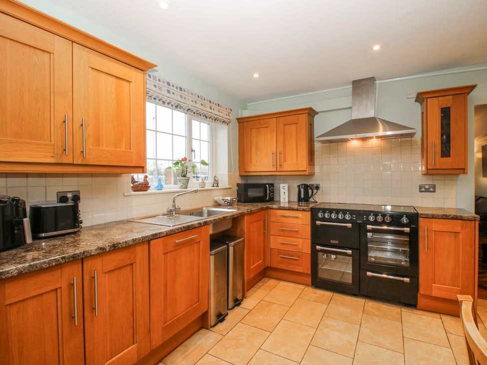 A kitchen with wooden cabinets and appliances at The Rumbles in 