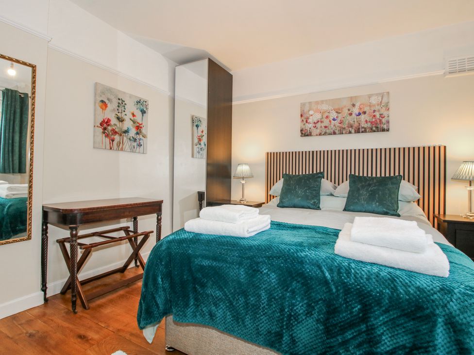 A bedroom with a bed and bedside lamps at The Rumbles