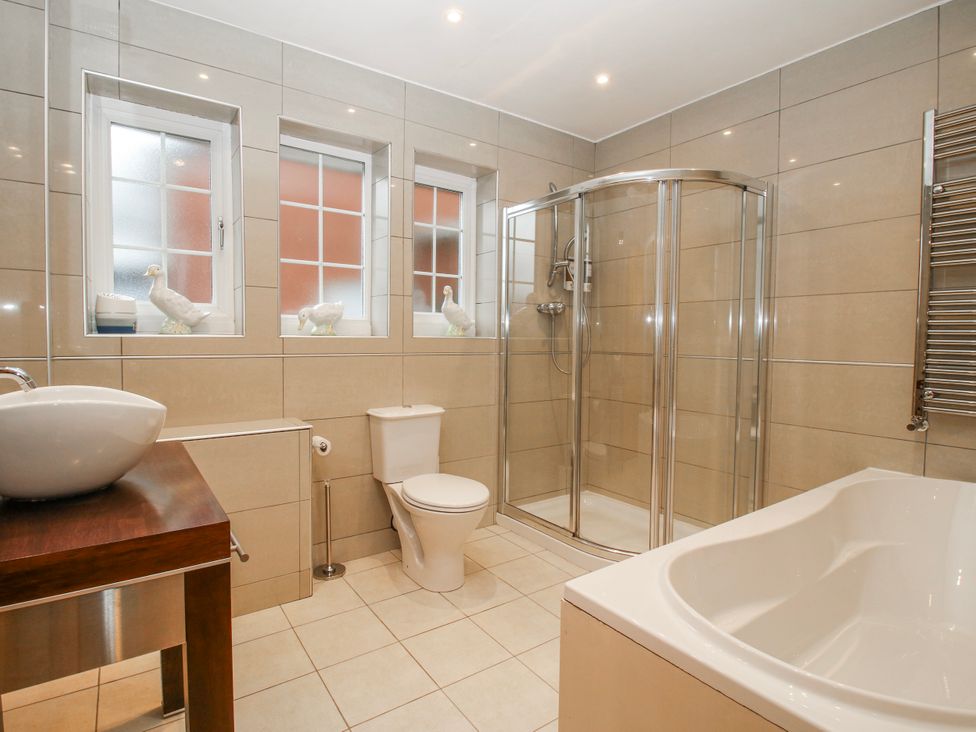 A bathroom with a shower, bathtub, and toilet at The Rumbles