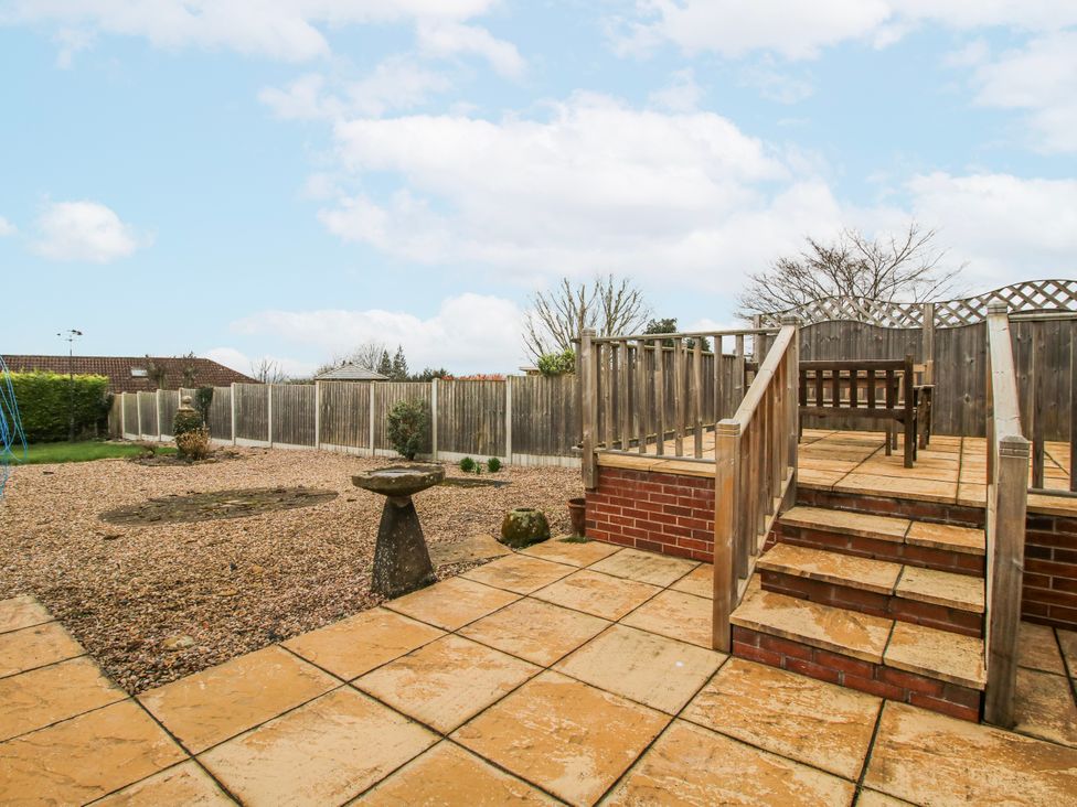 A garden area with a patio, steps, and fencing at The Rumbles in 