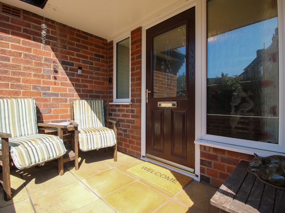 An outdoor area with chairs and a welcome mat at The Rumbles in Ludlow