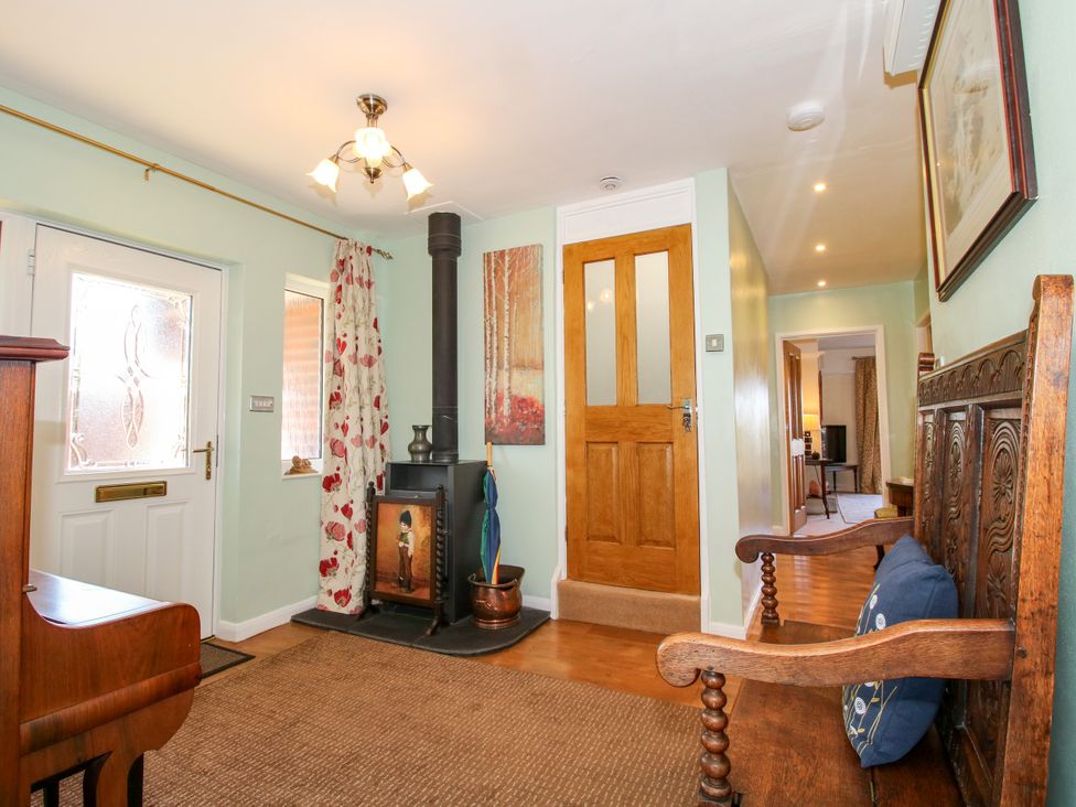 A hallway with a wooden bench and a stove at The Rumbles in Ludlow