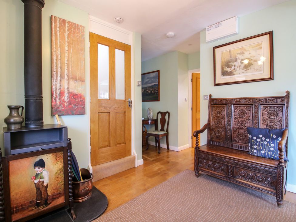 A hallway with a bench and artwork at The Rumbles in Ludlow