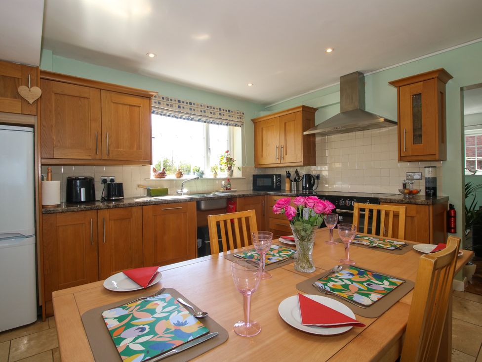 A kitchen with wooden cabinets and dining table at The Rumbles in Ludlow