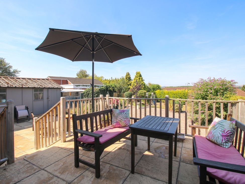 A garden with seating area and umbrella at The Rumbles in Ludlow
