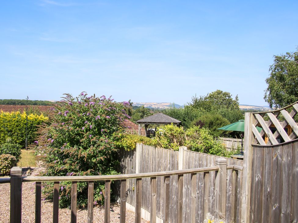 A garden with a fence and gazebo at The Rumbles in Ludlow