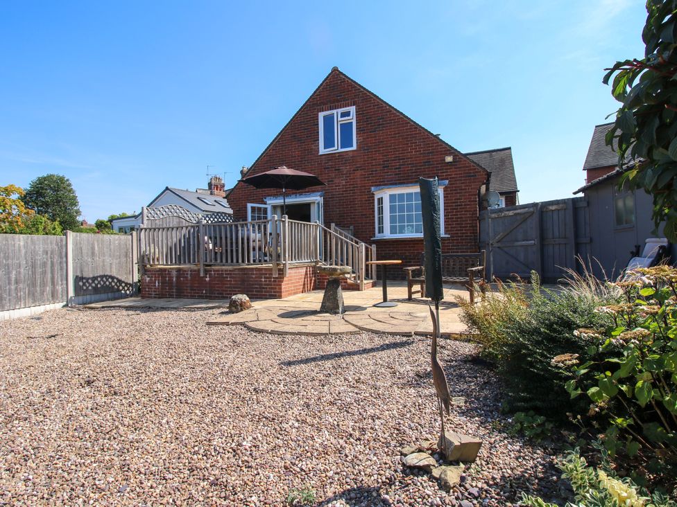 A garden with a house, deck, and gravel at The Rumbles in Ludlow
