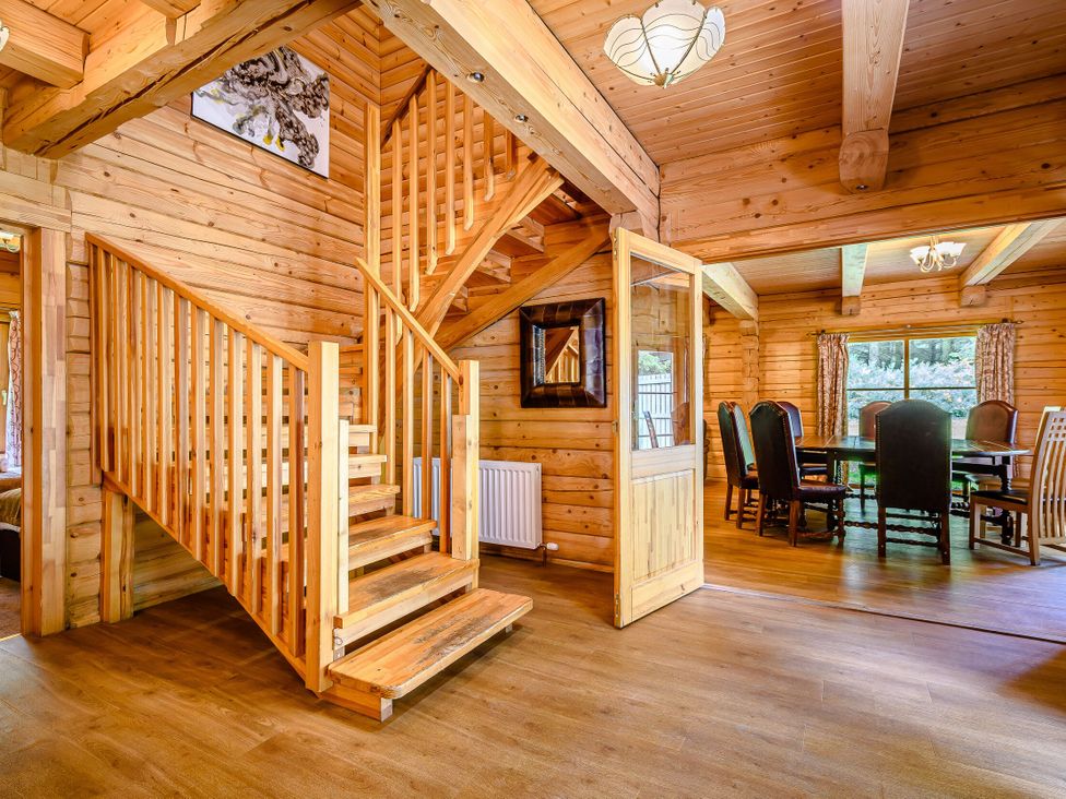 A dining room with a staircase and wooden furniture at Foresters Spa Plus in Dundee