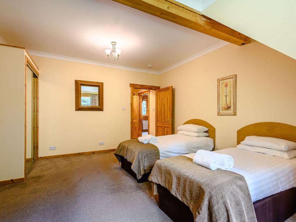 A bedroom with two beds and a mirror at Foresters Spa Plus in Dundee