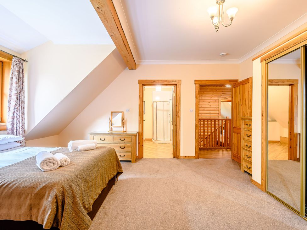 A bedroom with a bed and mirror at Foresters Spa Plus in Dundee