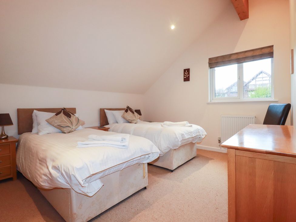 A bedroom with two beds and a desk at 65 Benasa Lodge, Winnard's Perch near St Columb Major