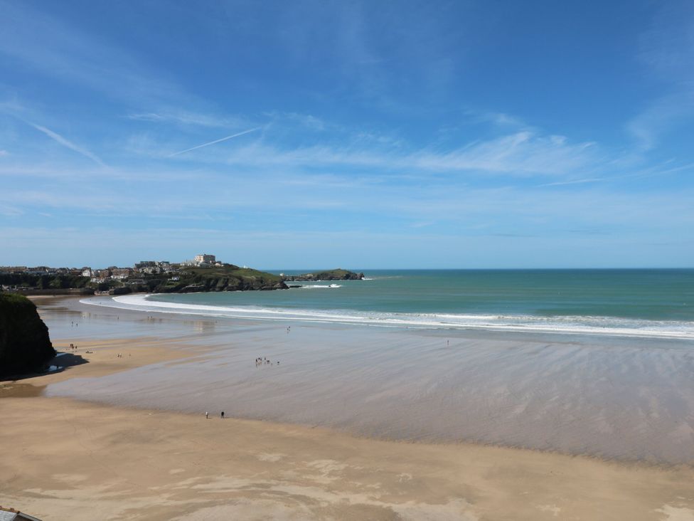 A beach with ocean waves and people at 65 Benasa Lodge, Winnard's Perch near St Columb Major