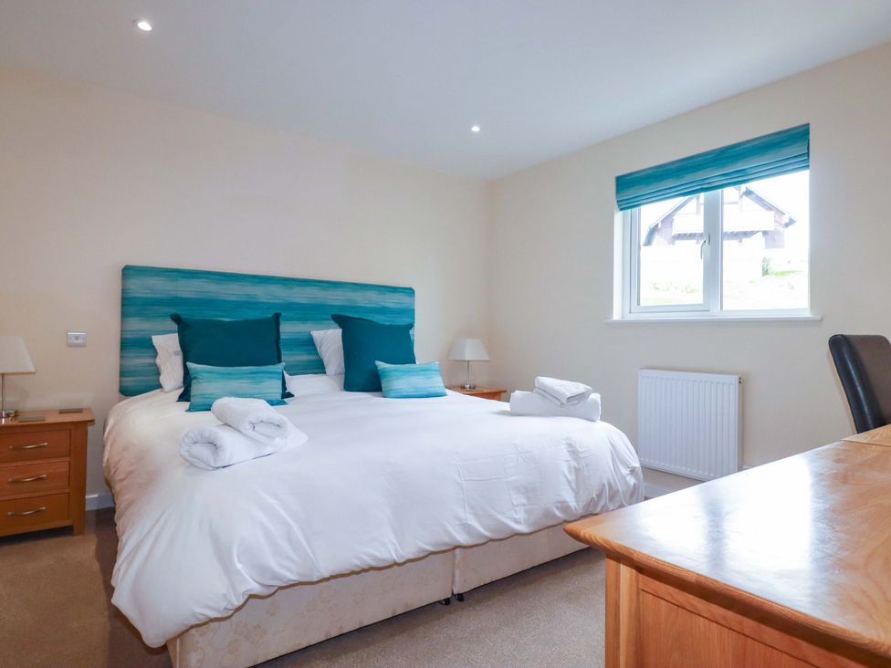 A bedroom with a bed, bedside table, and desk at 65 Benasa Lodge in Winnard's Perch near St Columb Major