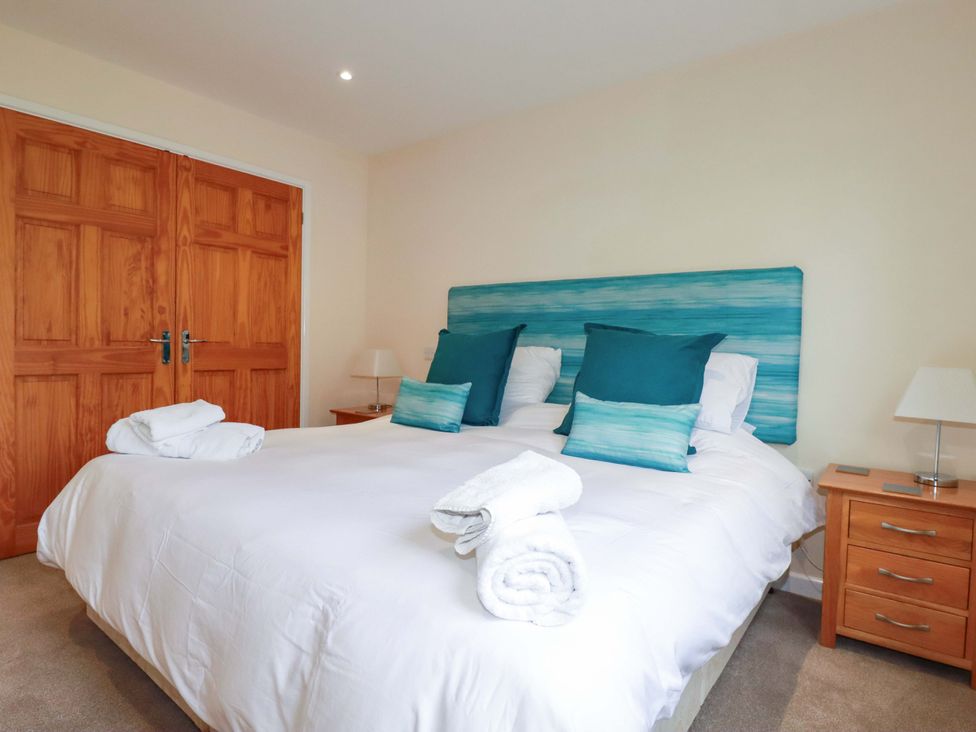 A bedroom with a bed and folded towels at 65 Benasa Lodge in Winnard's Perch near St Columb Major