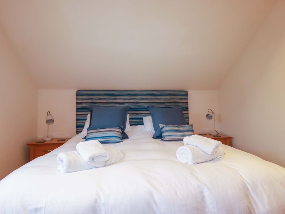 A bedroom with a bed and bedside lamps at 65 Benasa Lodge in Winnard's Perch near St Columb Major
