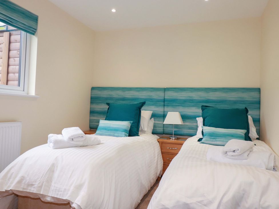 A bedroom with twin beds and a window at 65 Benasa Lodge near St Columb Major