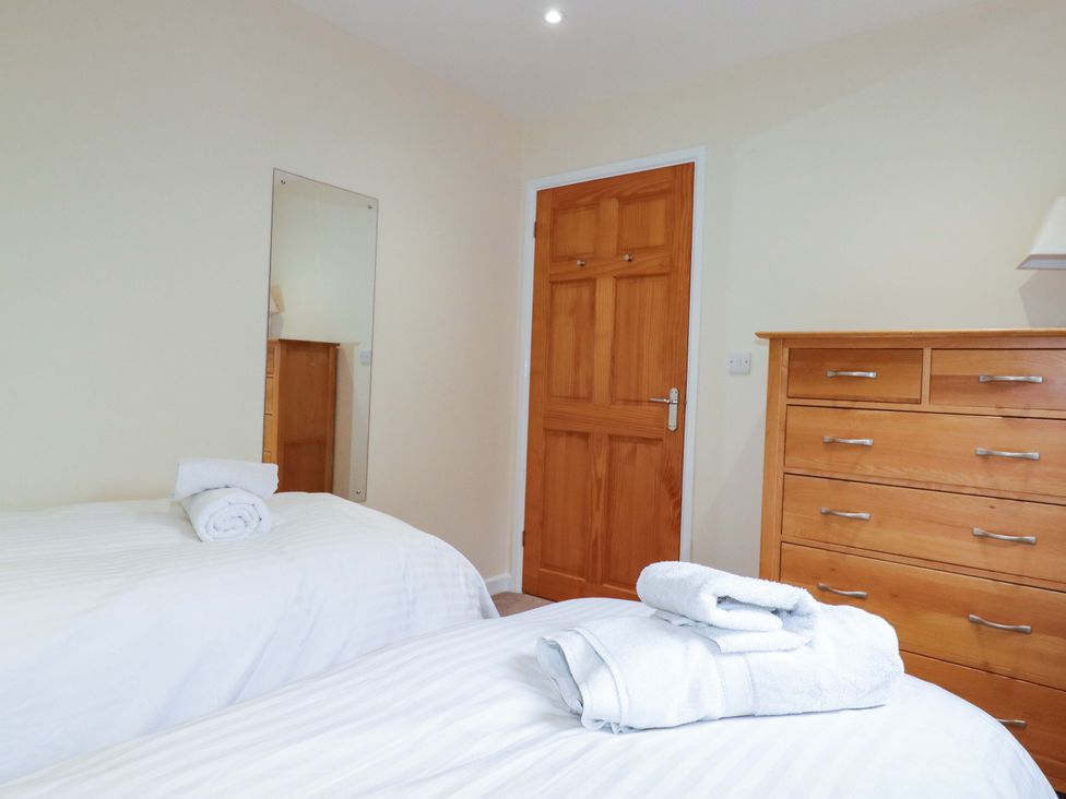 A bedroom with two beds and a chest of drawers at 65 Benasa Lodge in Winnard's Perch near St Columb Major