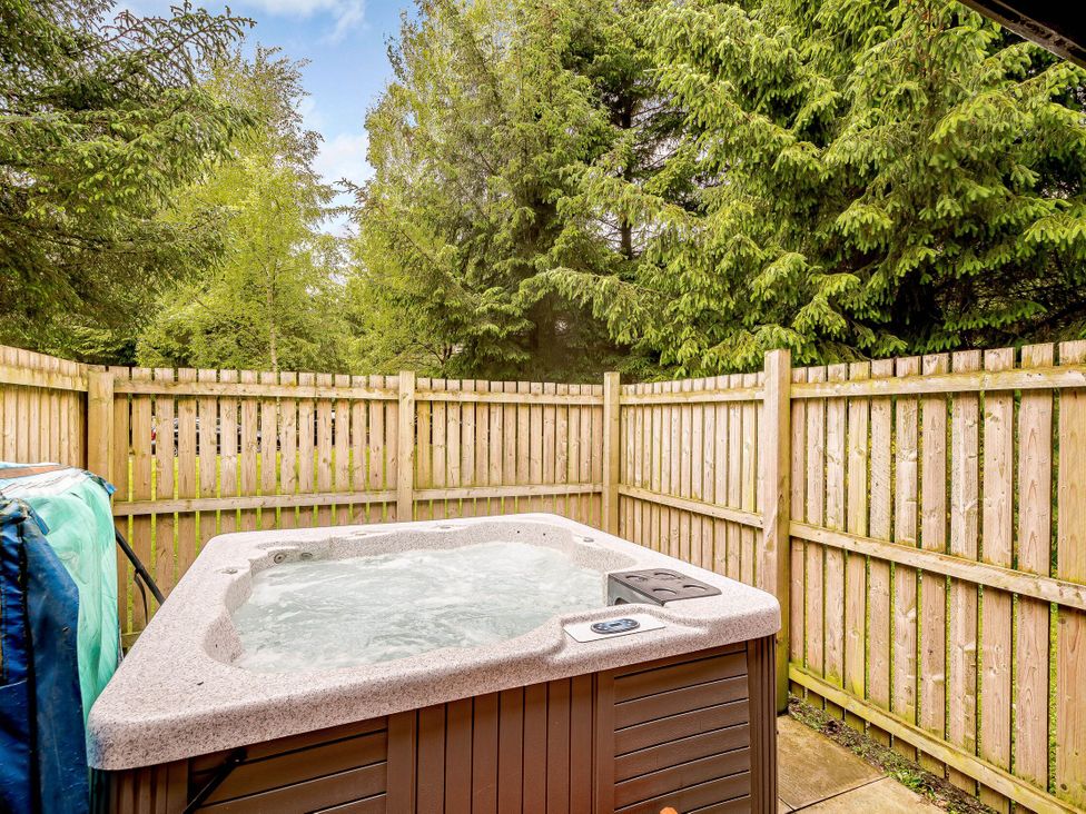 A hot tub surrounded by wooden fence and trees at Eagle Spa Plus in Dundee