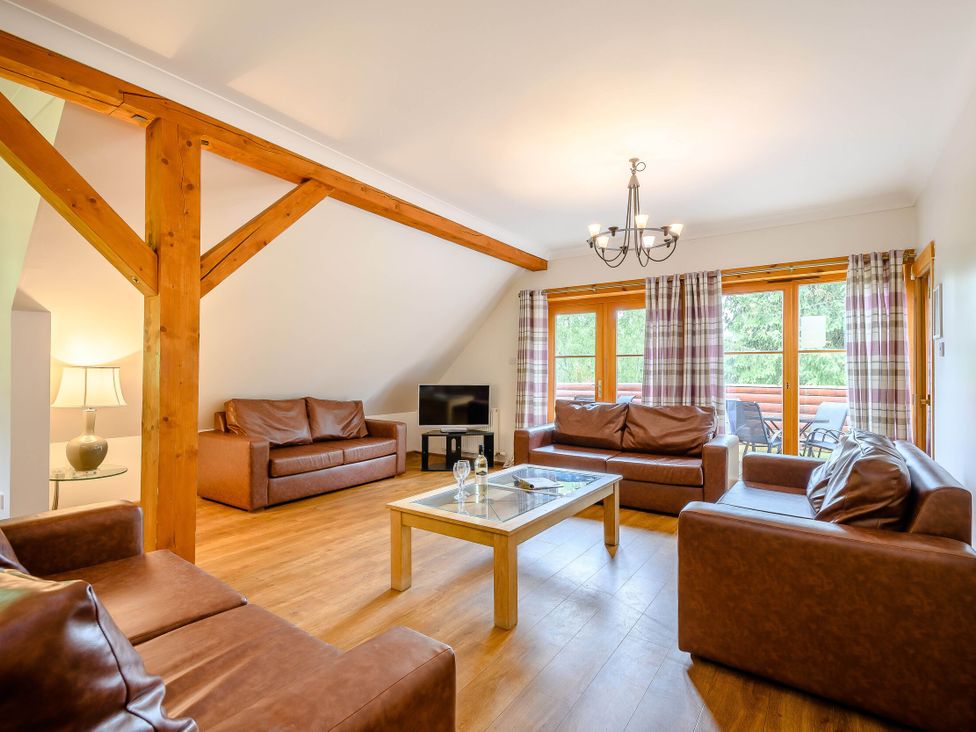 A living room with sofas and a coffee table at Eagle Spa Plus in Dundee