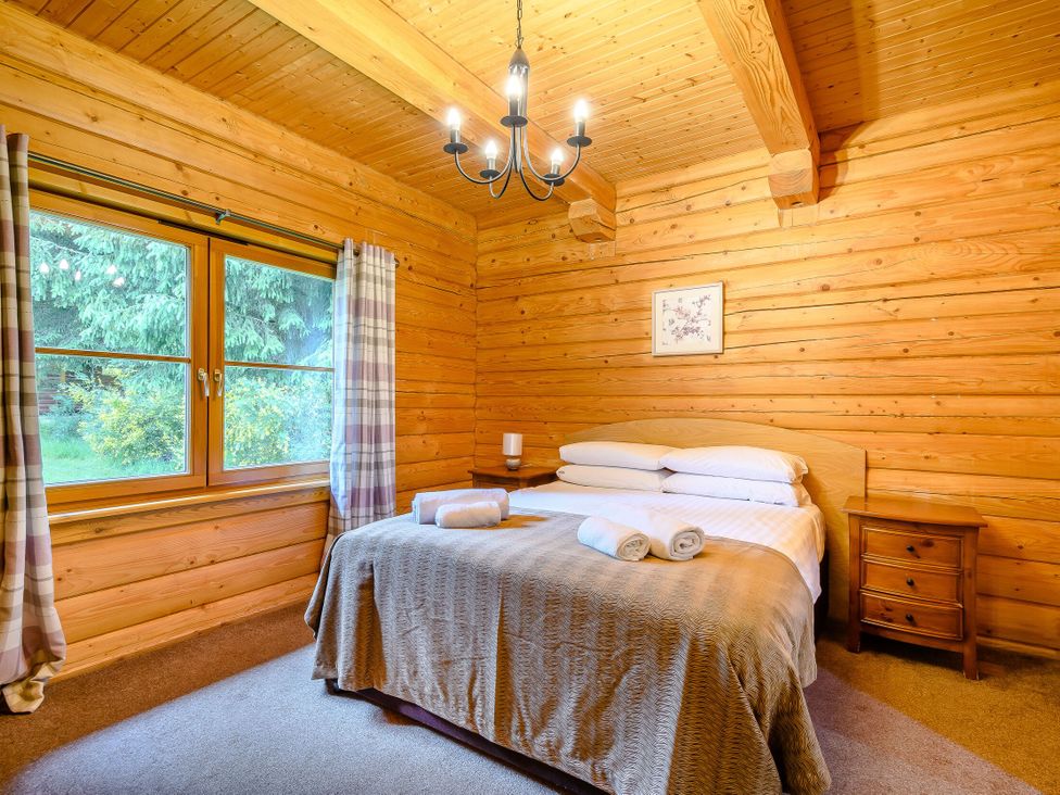 A bedroom with a bed and windows at Eagle Spa Plus in Dundee