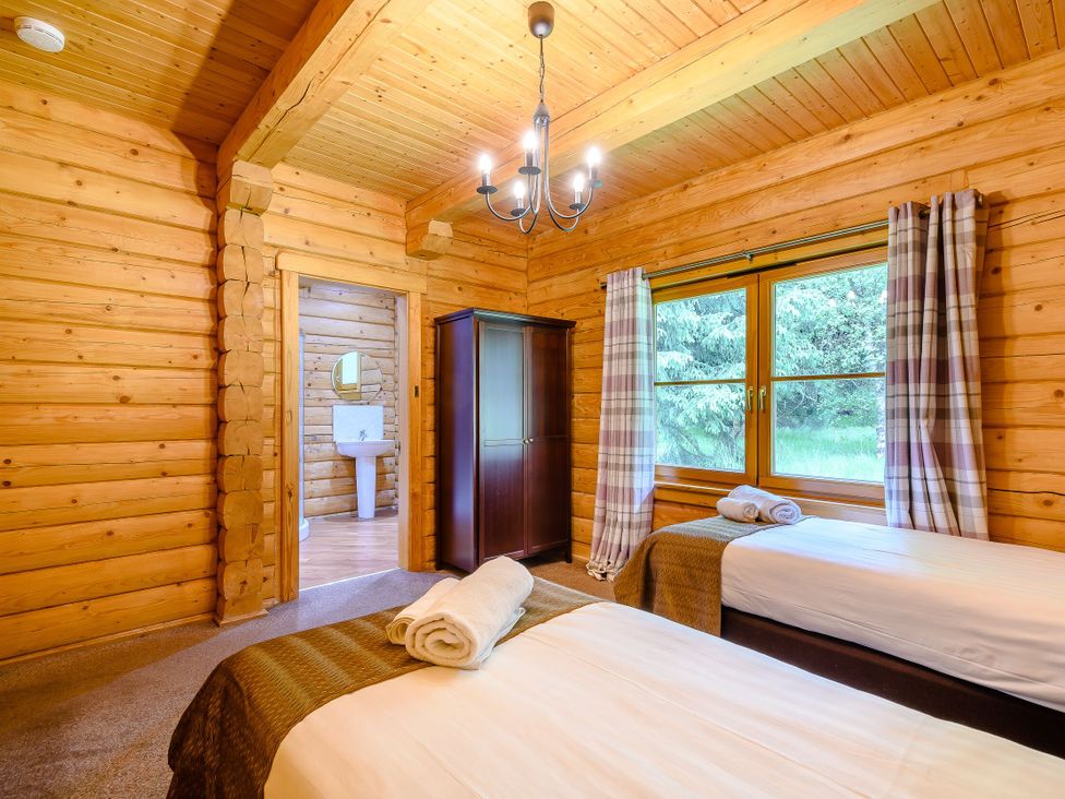 A bedroom with two beds and a wardrobe at Eagle Spa Plus in Dundee