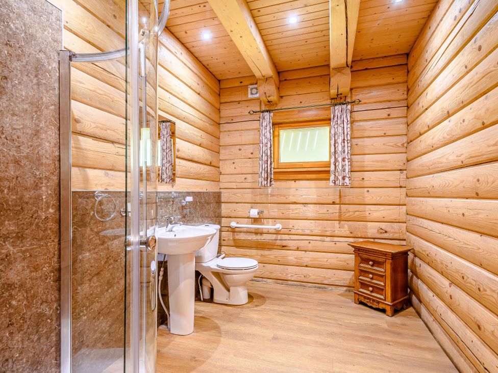 A bathroom with shower and wash basin at Foresters Spa Plus (Pet) Dundee