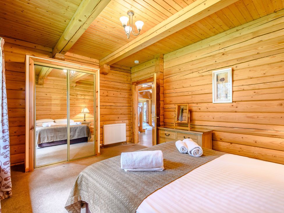 A bedroom with a bed and a mirror at Foresters Spa Plus (Pet) in Dundee