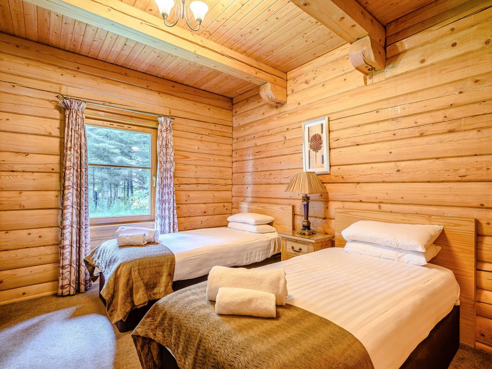 A bedroom with two beds and a window at Foresters Spa Plus (Pet) Dundee