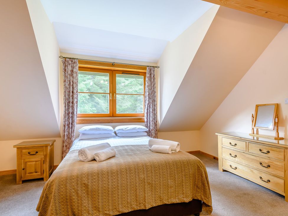 A bedroom with a bed and windows at Foresters Spa Plus (Pet) in Dundee