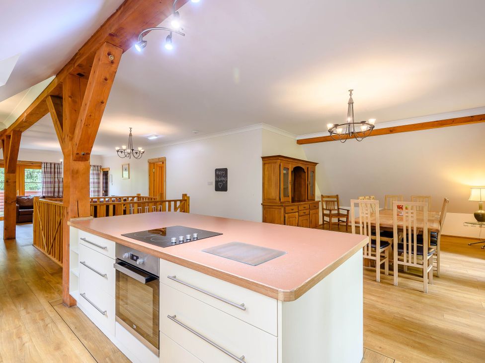A kitchen with an island stove and dining area at Eagle Spa Plus (Pet) in Dundee