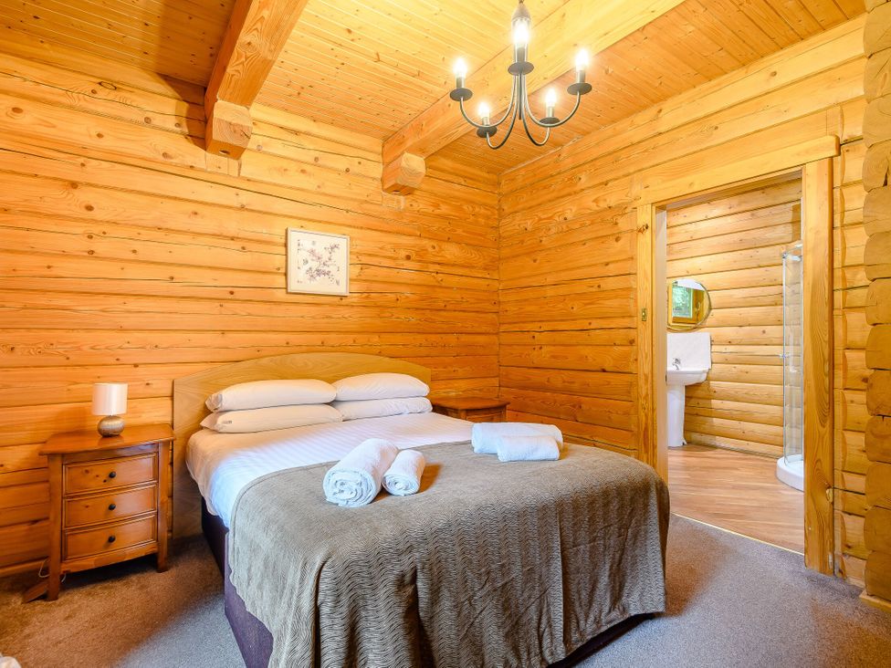 A bedroom with a bed and nightstand at Eagle Spa Plus (Pet) in Dundee