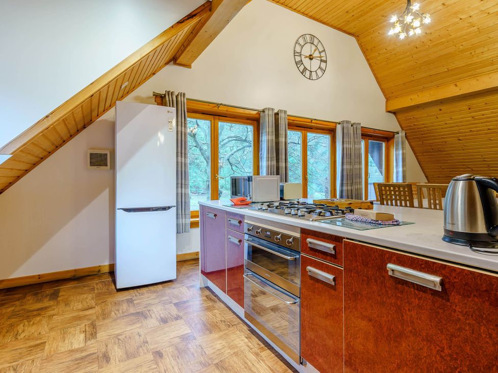 A kitchen with a refrigerator, stove, and cabinets at The Braveheart (Pet) Dundee