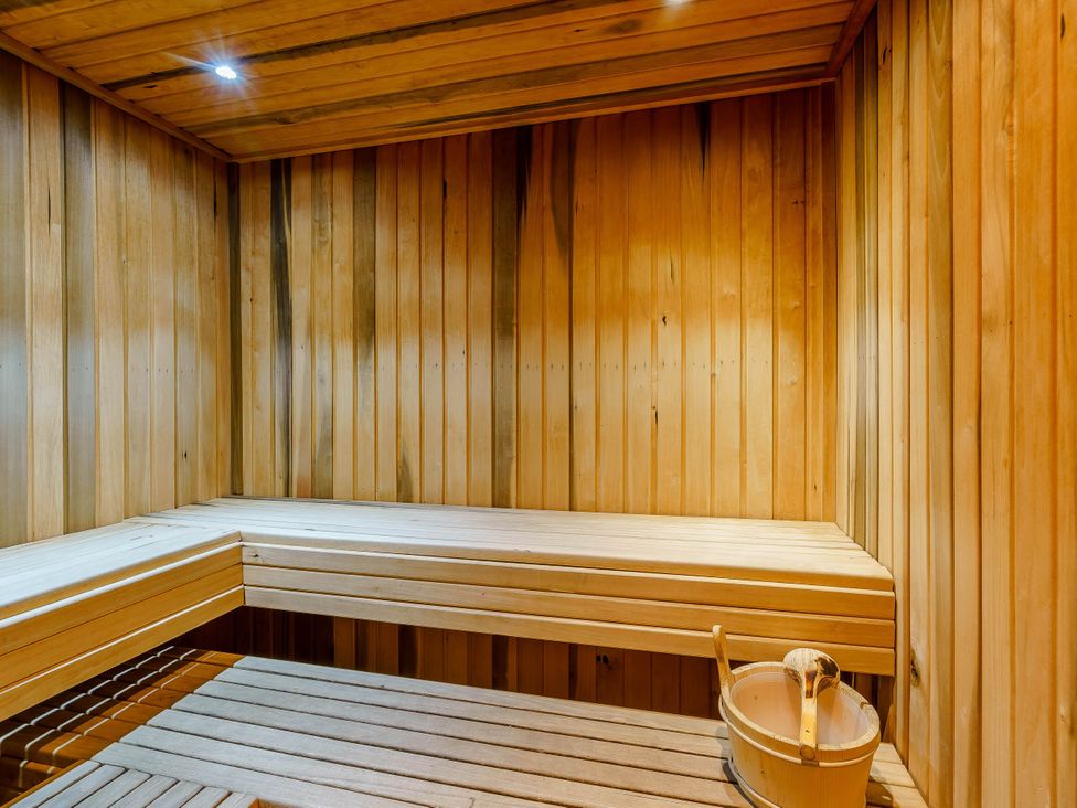 A sauna with wooden benches and a bucket at The Braveheart (Pet) Dundee