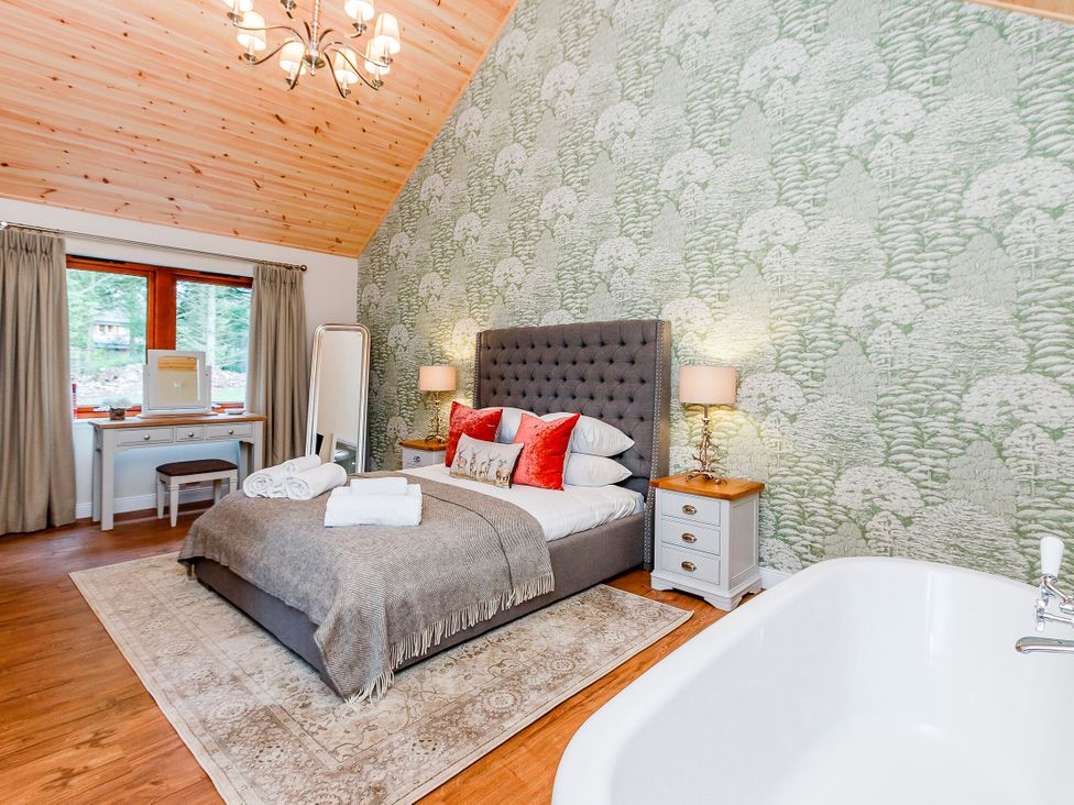 A bedroom with a bed and bathtub at Byron Premier Spa in Dundee