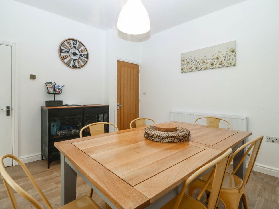 A dining room with a wooden table and chairs at Mona Lodge in Llandudno