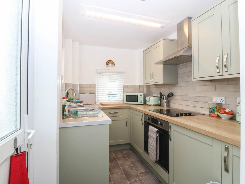 A kitchen with sink, stove, and cabinets at Mona Lodge in Llandudno