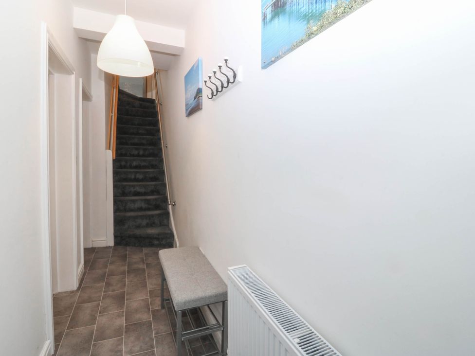 A hallway with a bench and stairs at Mona Lodge in Llandudno