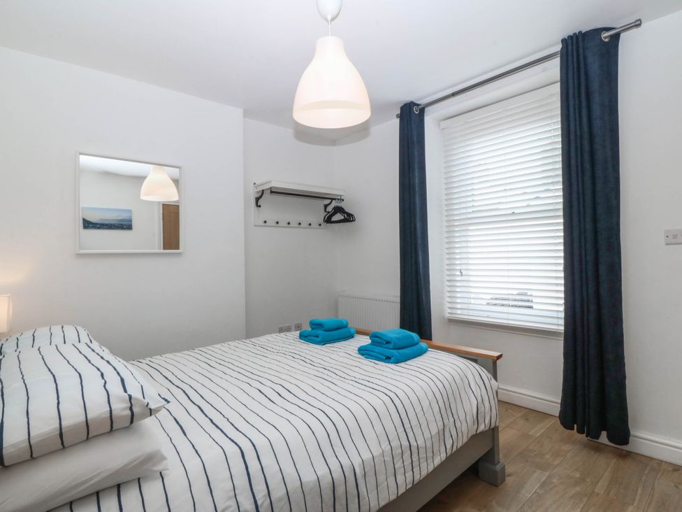 A bedroom with a bed and mirror at Mona Lodge in Llandudno
