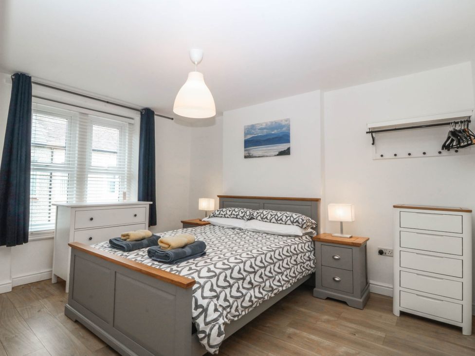A bedroom with a bed, bedside table, and dresser at Mona Lodge in Llandudno