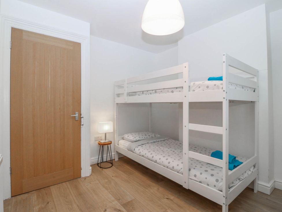 A bedroom with a bunk bed and a lamp at Mona Lodge in Llandudno