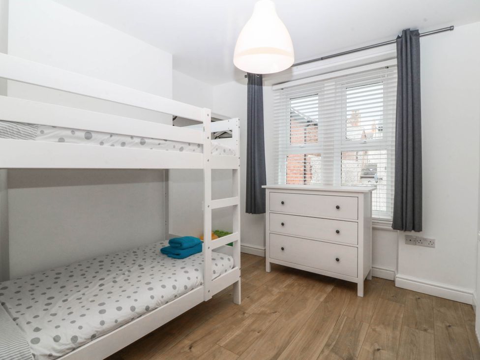 A bedroom with a bunk bed and a dressing table at Mona Lodge in Llandudno