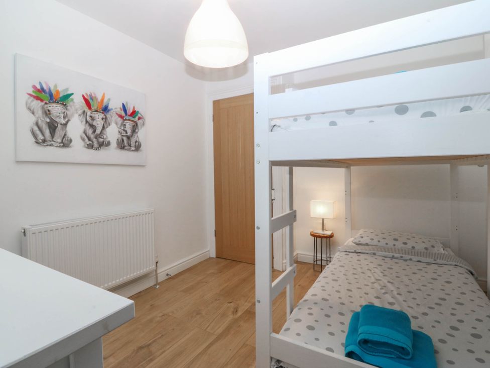 A bedroom with a bunk bed and a lamp at Mona Lodge in Llandudno