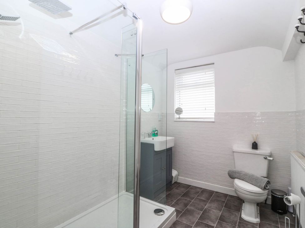 A bathroom with a shower, toilet, and sink at Mona Lodge in Llandudno