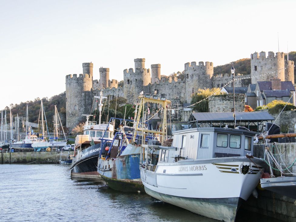 A marina with boats and a castle in the background at Mona Lodge in Llandudno
