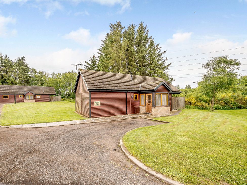 A wooden house with a lawn at Muirloch Spa Plus in Dundee