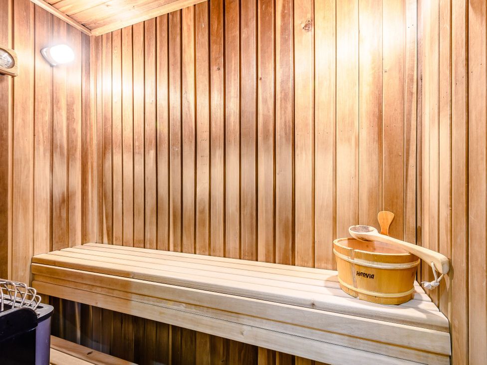 A sauna with wooden bench and bucket at Muirloch Spa Plus Dundee