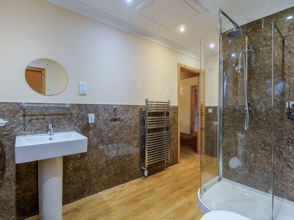 A bathroom with shower and wash basin at Muirloch Spa Plus (Pet) Dundee