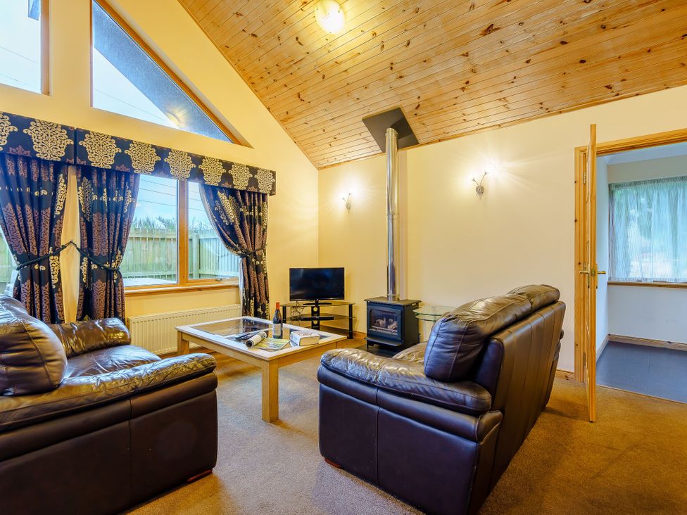 A living room with a sofa and television at Muirloch Spa Plus (Pet) Dundee