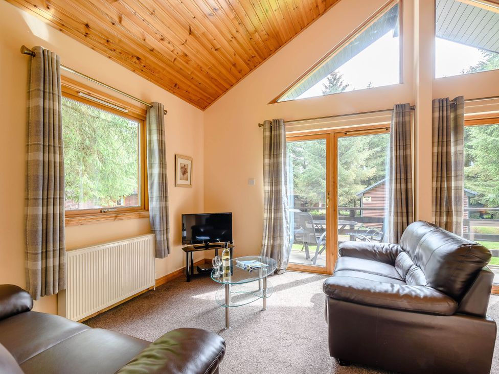 A living room with a television and coffee table at Barnard Lodge in Dundee