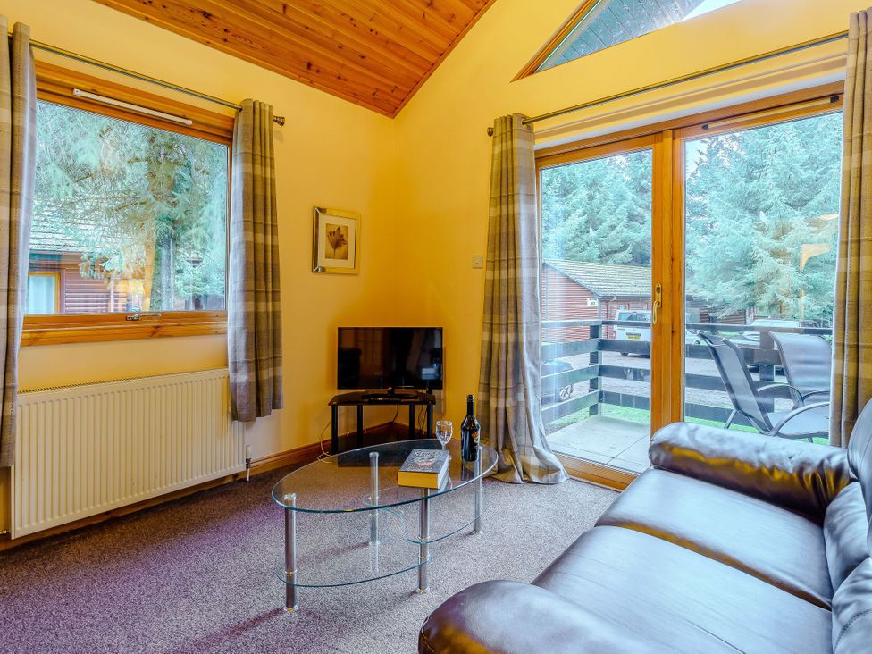 A living room with a tv and a coffee table at Rainbow Lodge in Dundee